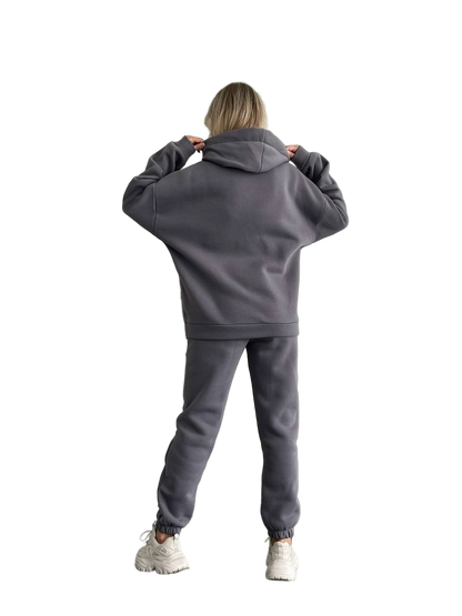 Person wearing a gray tracksuit on a white background