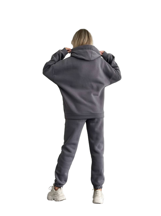 Person wearing a gray tracksuit on a white background