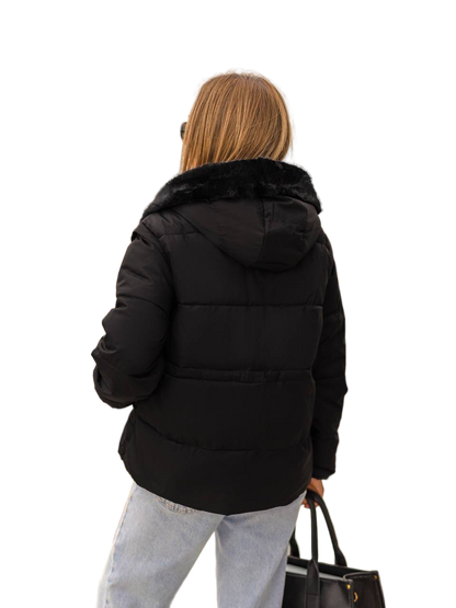 Person wearing a black puffer jacket with fur hood on a white background
