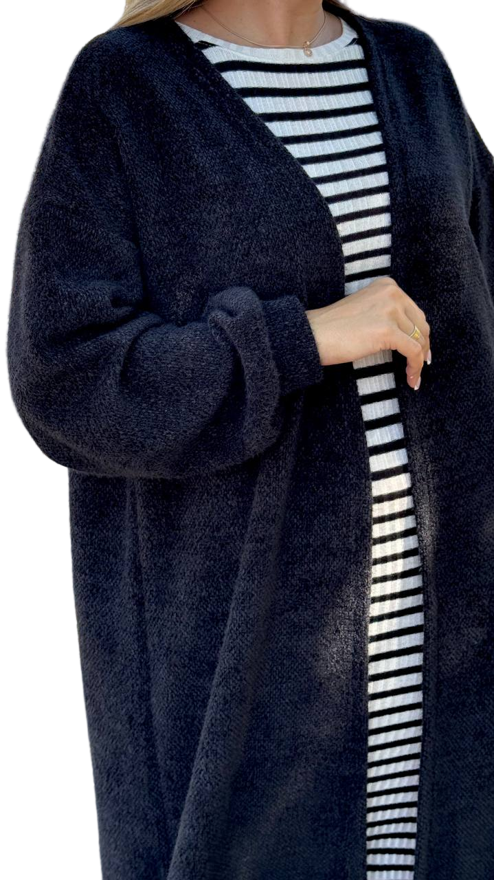 Person wearing a navy cardigan over a striped shirt on a white background
