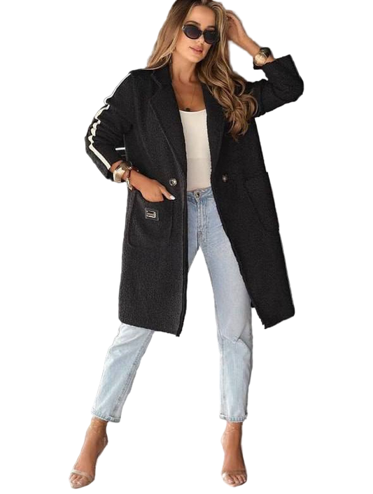 Woman wearing a black coat, white top, and light blue jeans on a white background