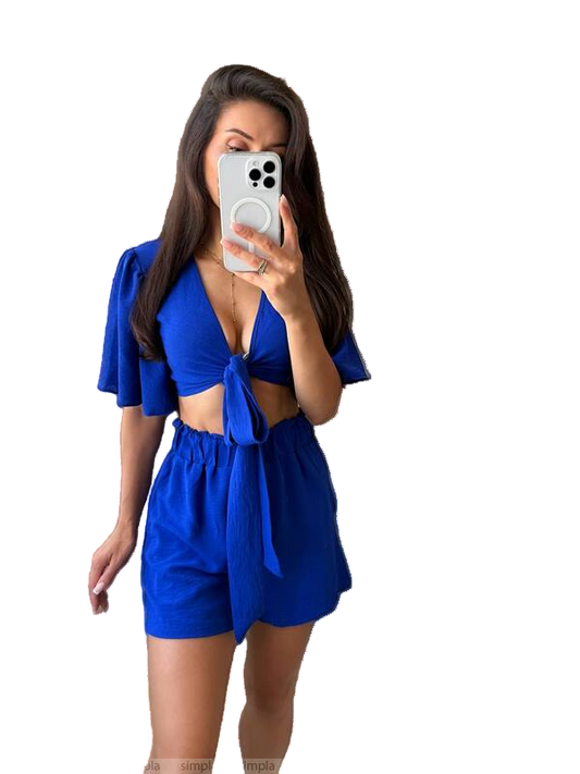 Woman taking a mirror selfie wearing a blue outfit.