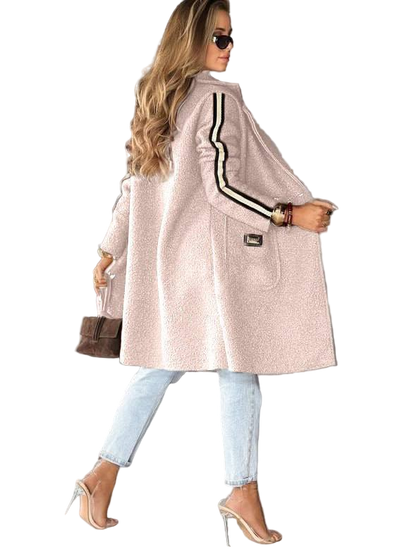 Woman wearing a light pink coat with black stripes on a white background
