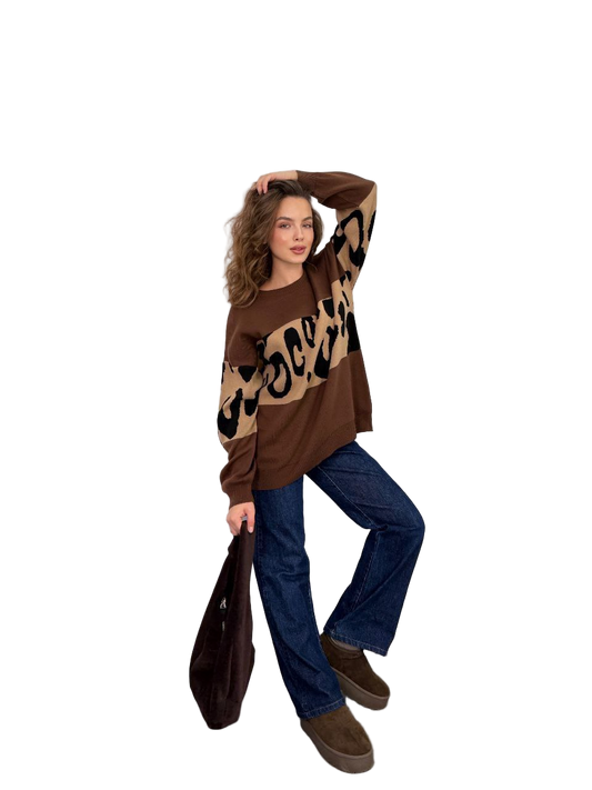 Woman wearing a brown sweater with leopard print and blue jeans on a white background