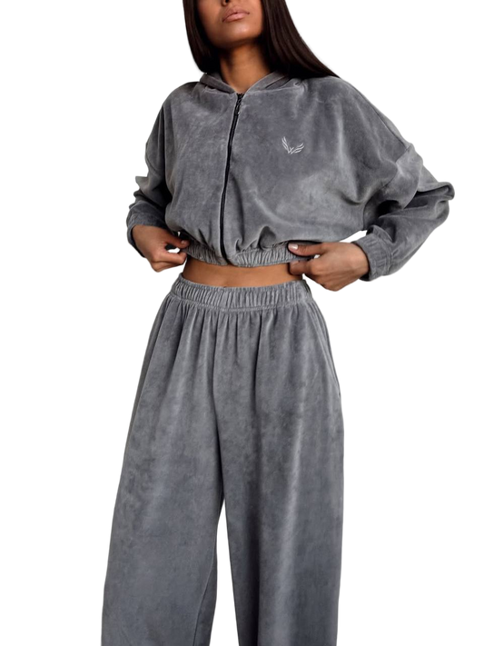 Person wearing a gray tracksuit with a brand logo on a white background
