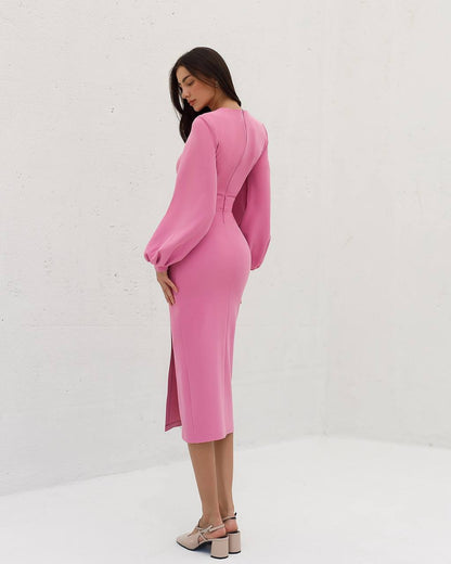 Woman wearing a pink dress with balloon sleeves against a white background