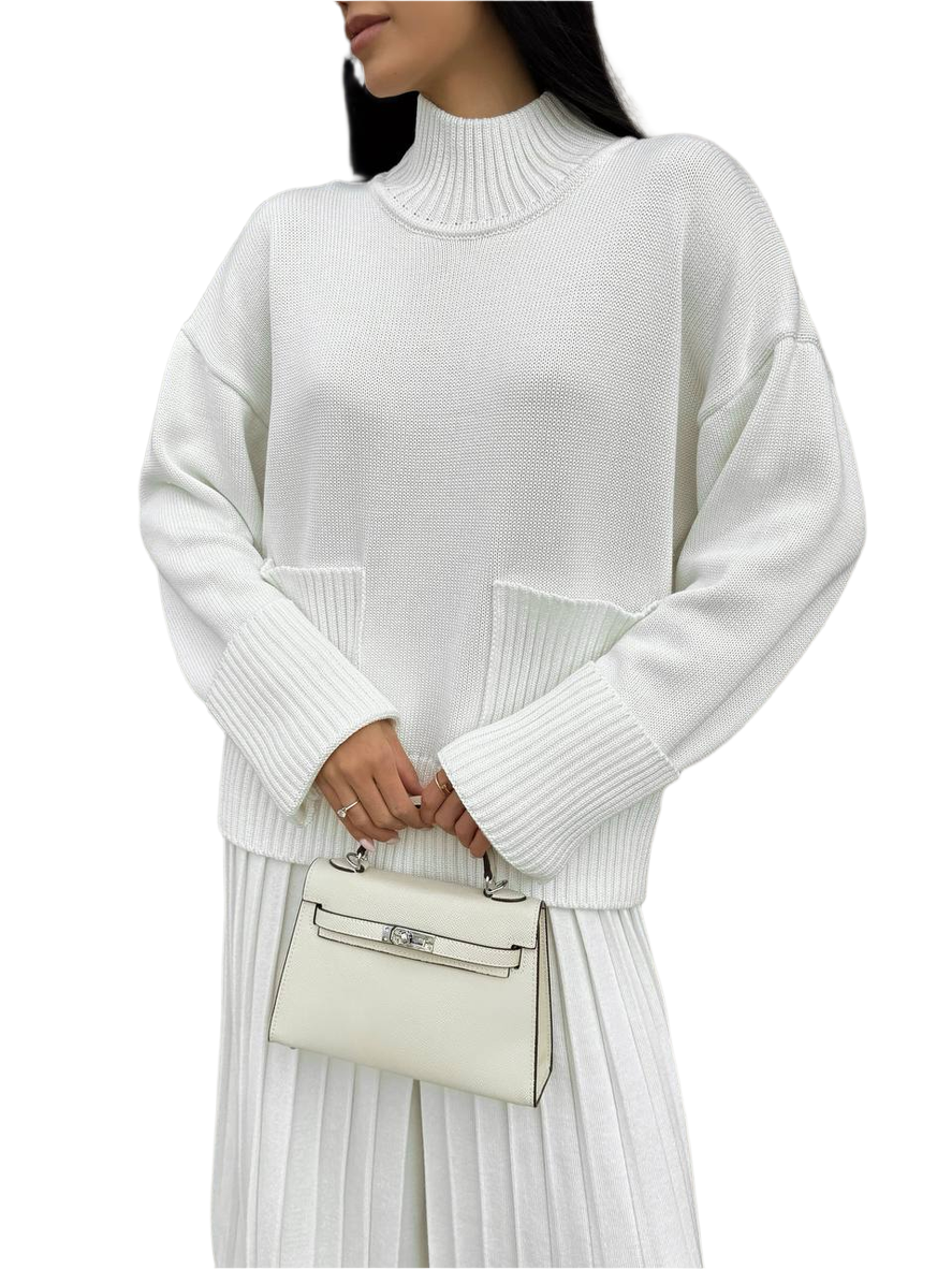 Person wearing a white ribbed sweater and holding a matching handbag on a white background