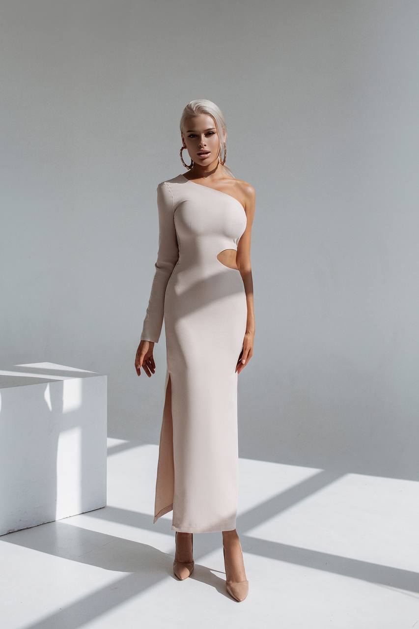 Woman wearing a one-shoulder dress with a cutout design in a minimalistic setting