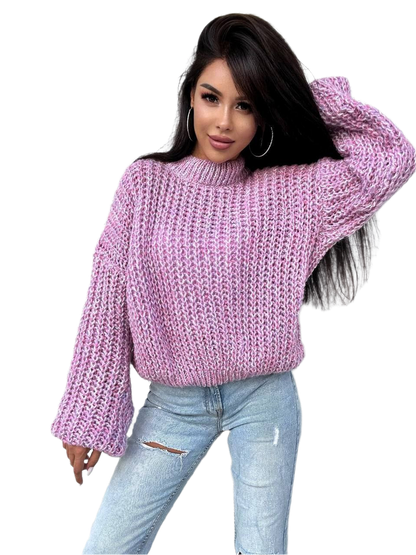 Woman wearing a pink knitted sweater and light blue jeans on a white background
