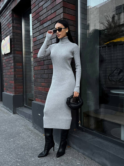 Woman in a gray dress standing outside a building