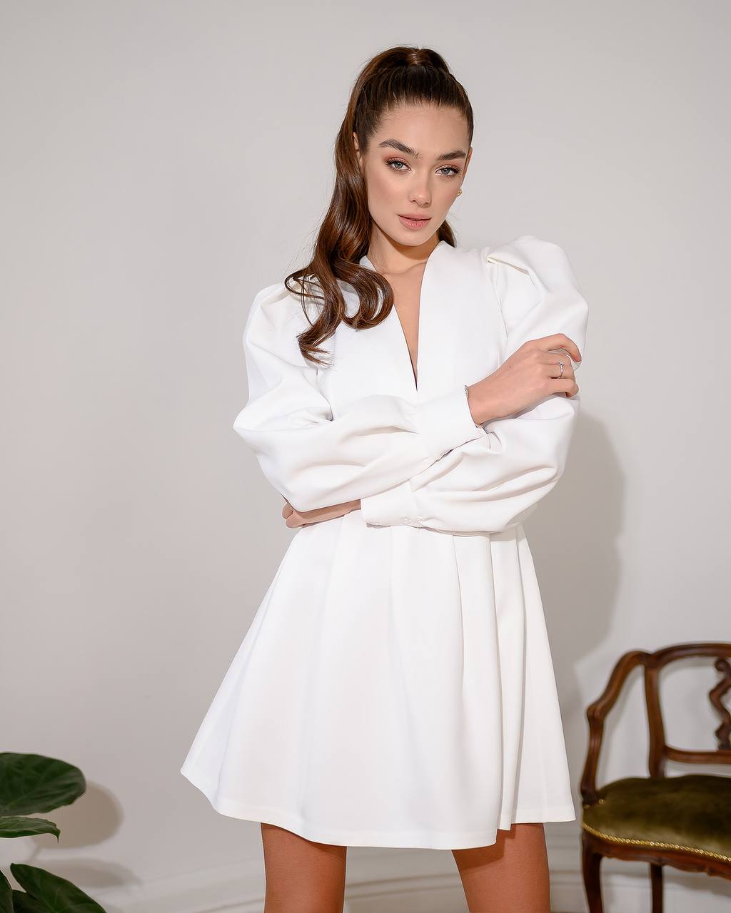 Woman wearing a white dress against a plain background