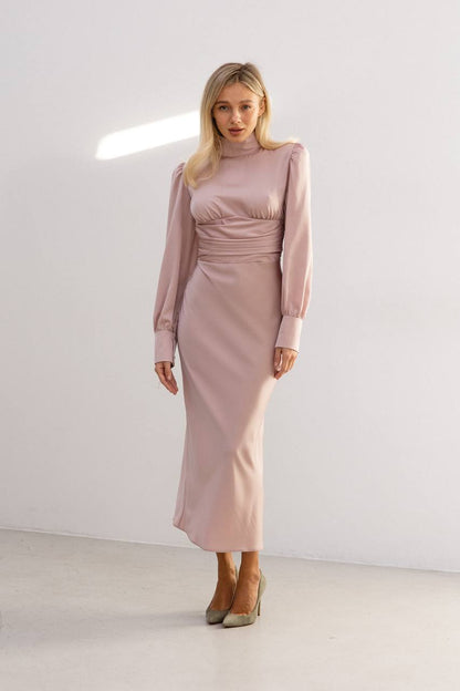 Woman wearing a pink dress standing against a white background