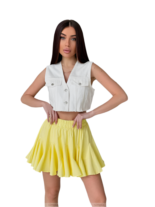 Woman wearing a white sleeveless denim jacket and yellow skirt on a white background