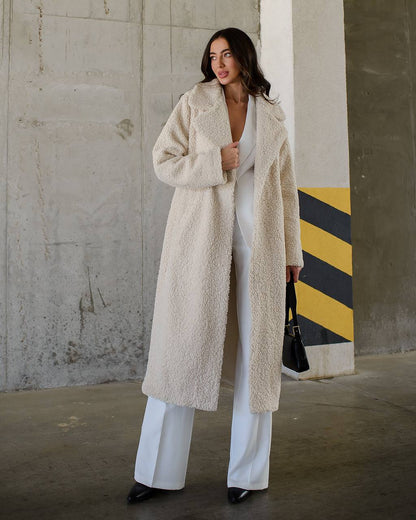Woman wearing a long beige coat in an urban setting