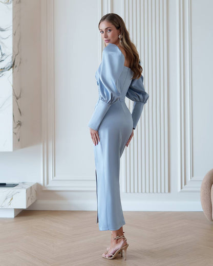 Woman in a light blue outfit standing in a stylish interior setting