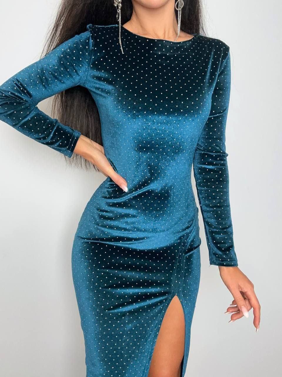Teal glittery dress with long sleeves and a slit on a white background