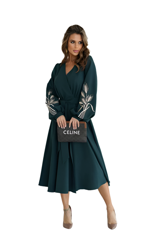 Woman wearing a dark green dress with floral embellishments, holding a Celine handbag on a white background.