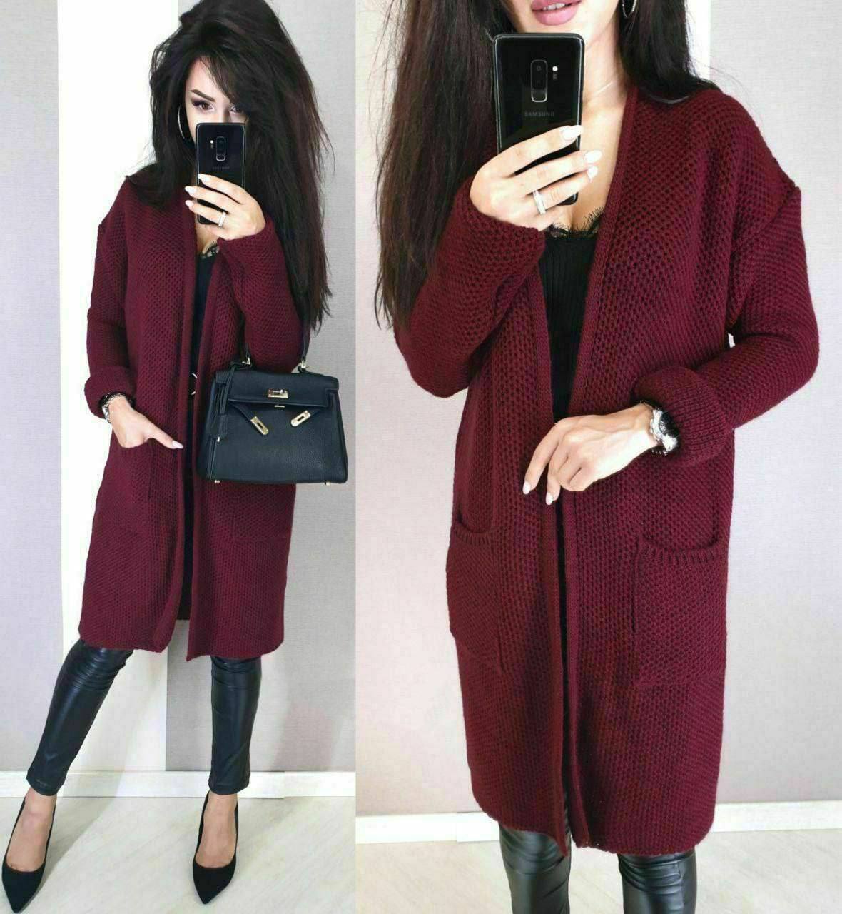 Woman wearing a burgundy cardigan with a plain background