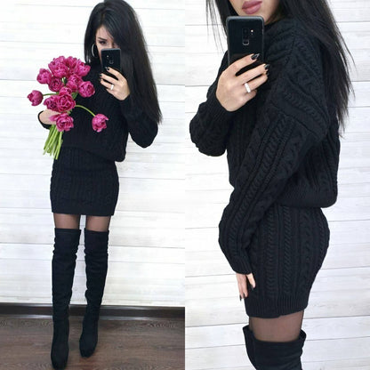 Woman wearing a black cable knit sweater dress with knee-high boots, holding pink flowers.