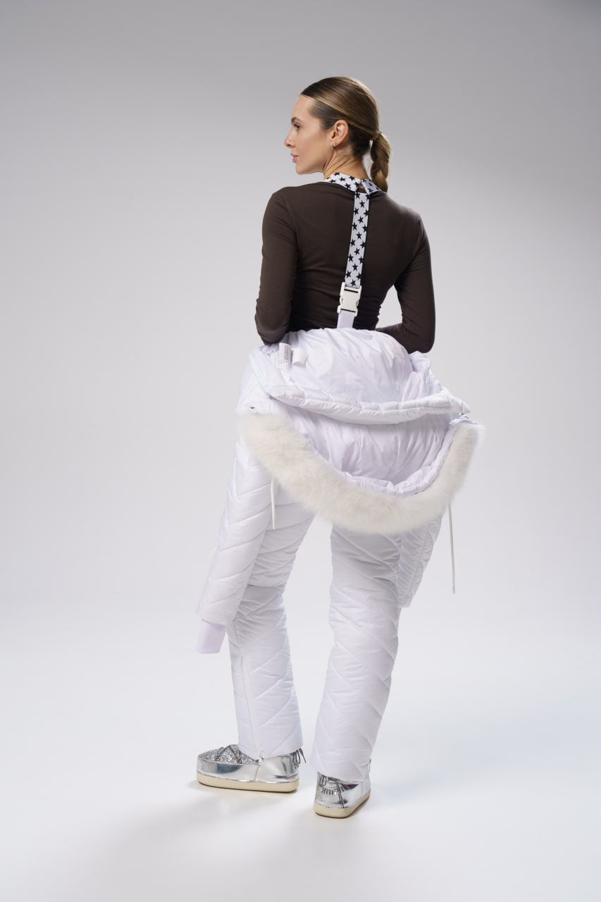 Person wearing a white apron over a dark outfit on a plain background