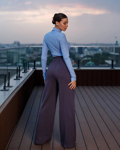 Woman standing on a rooftop deck with a cityscape in the background