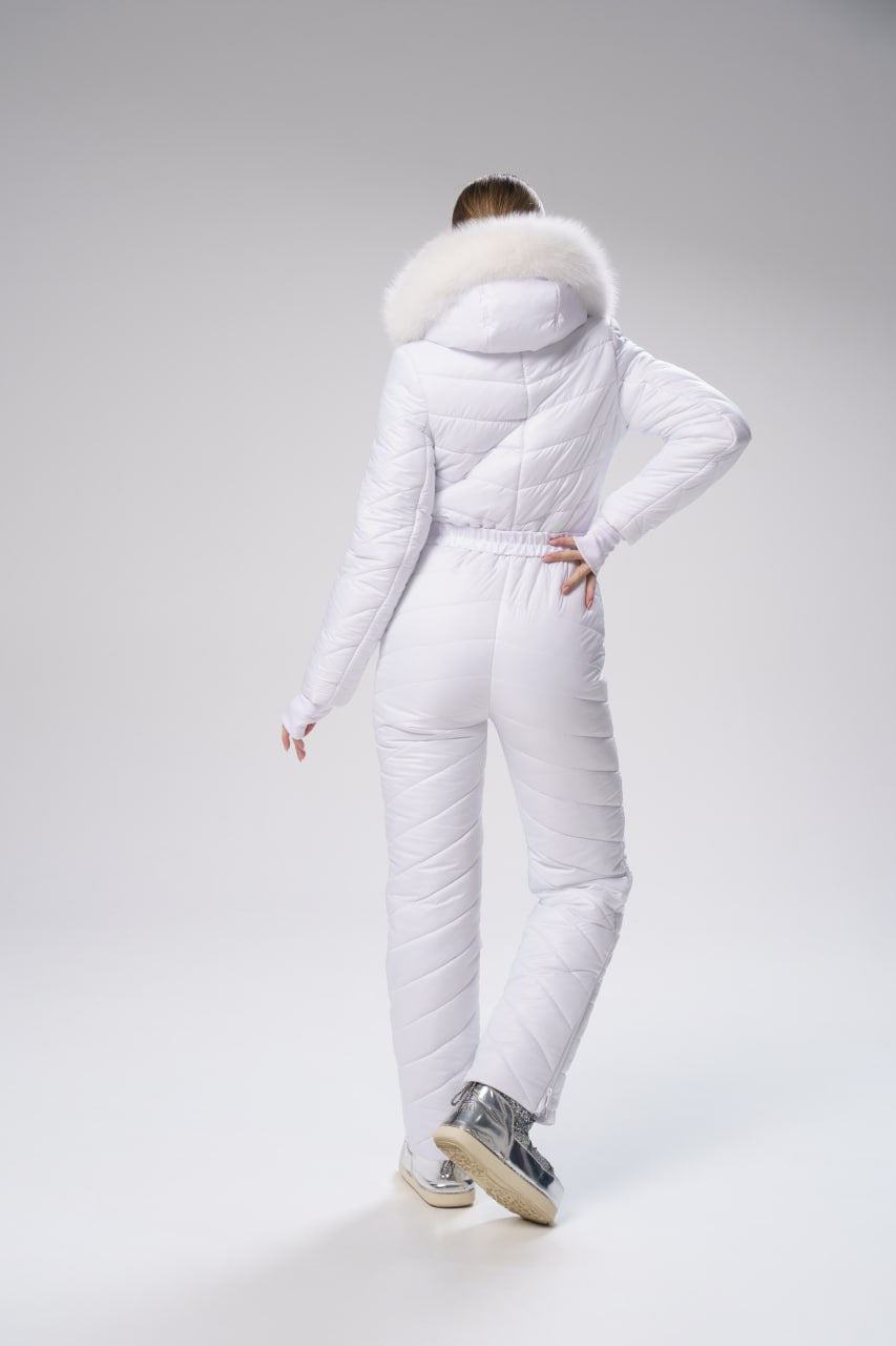 Person wearing a white puffer suit with a fur-lined hood on a gray background