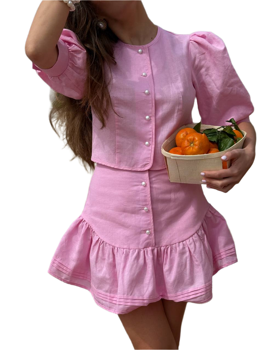 Person wearing a pink dress holding a basket of oranges on a white background