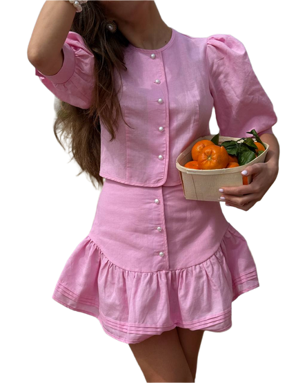 Person wearing a pink dress holding a basket of oranges on a white background
