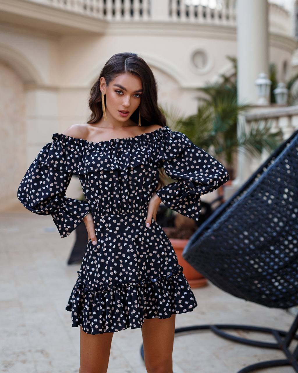 Woman wearing a black polka dot dress in an outdoor setting