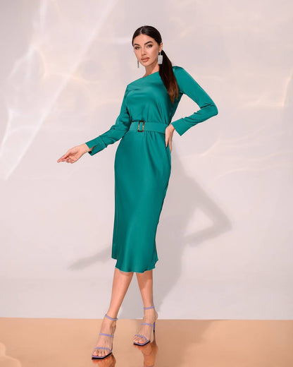 Woman wearing a teal dress against a white background