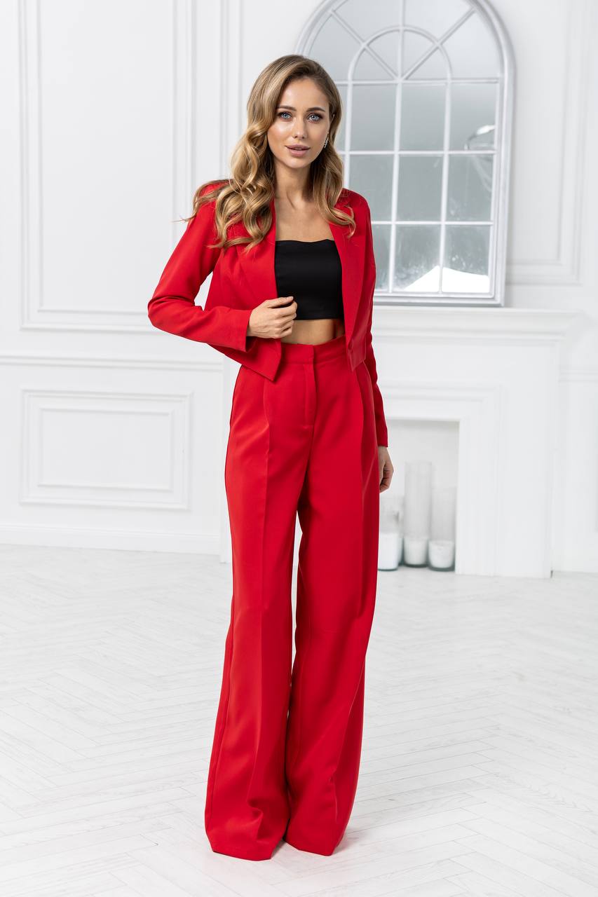 Woman wearing a red outfit with a black top in a bright room.