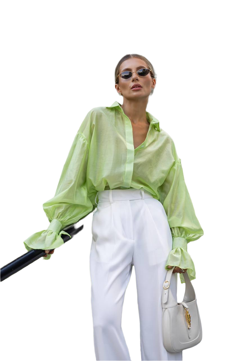 Woman wearing a light green blouse and white pants, holding a black umbrella and a white handbag on a white background.