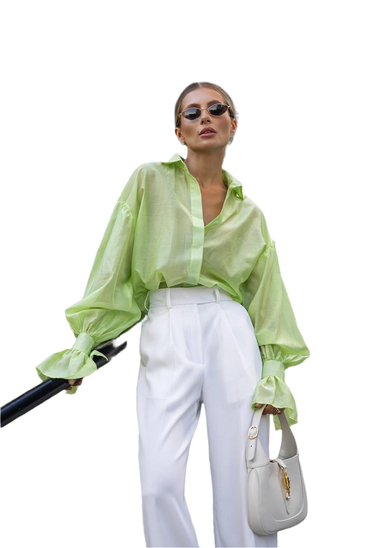 Woman wearing a light green blouse and white pants, holding a black umbrella and a white handbag on a white background.