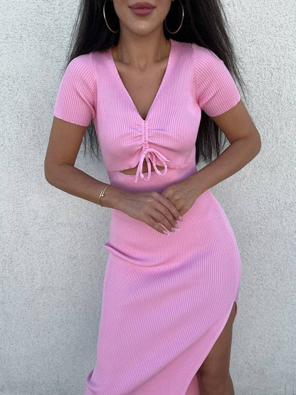 Person wearing a pink ribbed dress against a light gray background