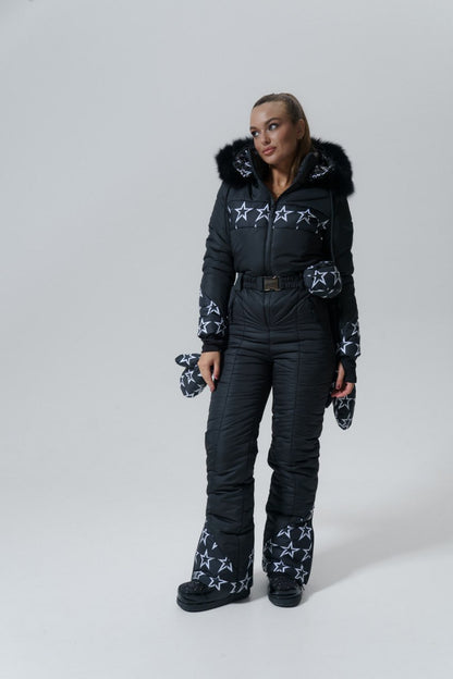 Person wearing a black snowsuit with star patterns on a white background