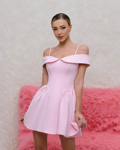 Woman wearing a pink off-shoulder dress against a pink textured background