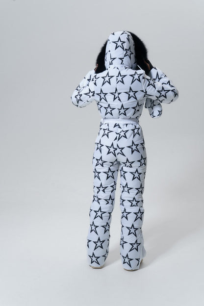 Person wearing a star-patterned onesie on a plain background
