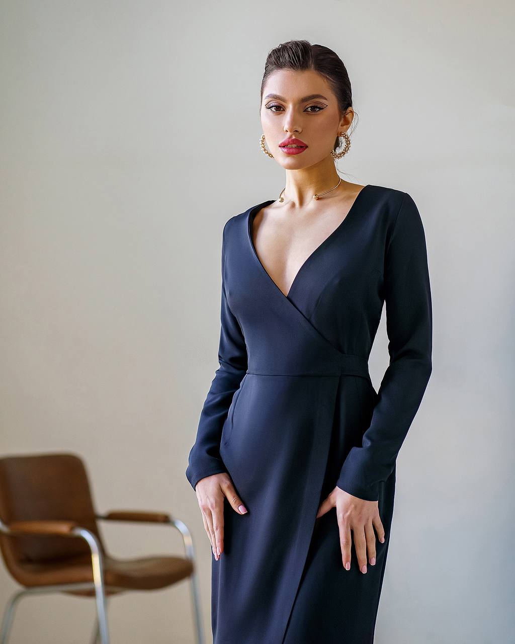 Woman wearing a dark blue dress against a plain background