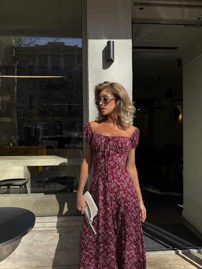 Woman in a floral dress standing outside a modern building