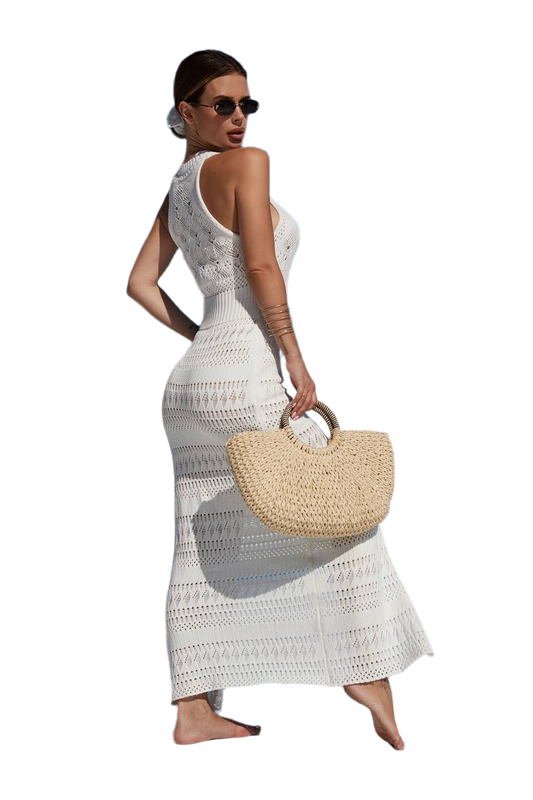 Woman in a white crochet dress holding a straw bag on a white background
