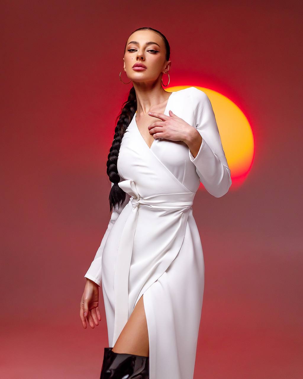 Woman in a white dress with a red and orange sun background