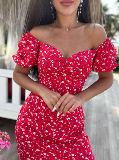 Woman wearing a red floral off-shoulder dress with blurred background