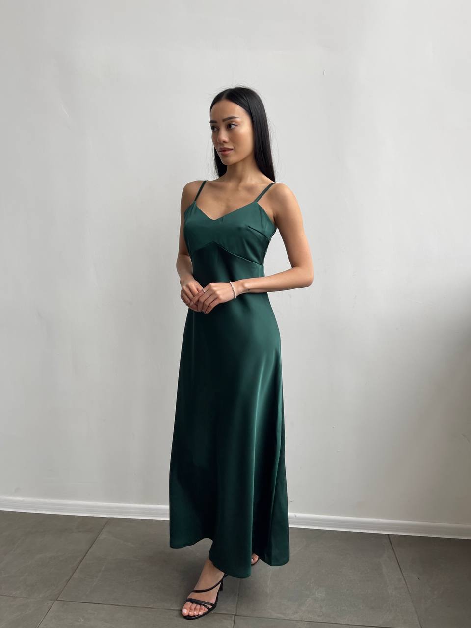 Woman wearing a green dress against a plain background