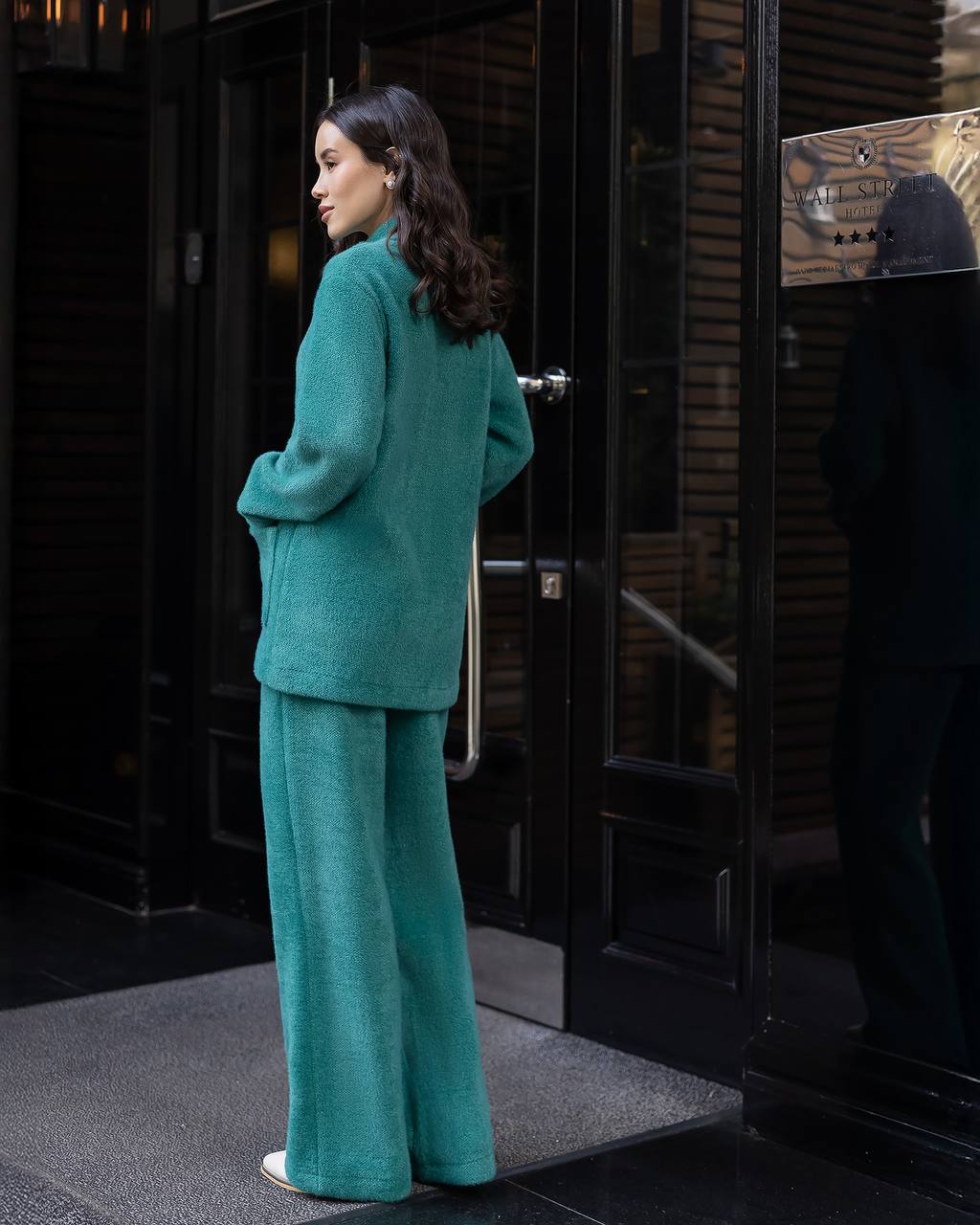Woman in teal outfit standing outside a building