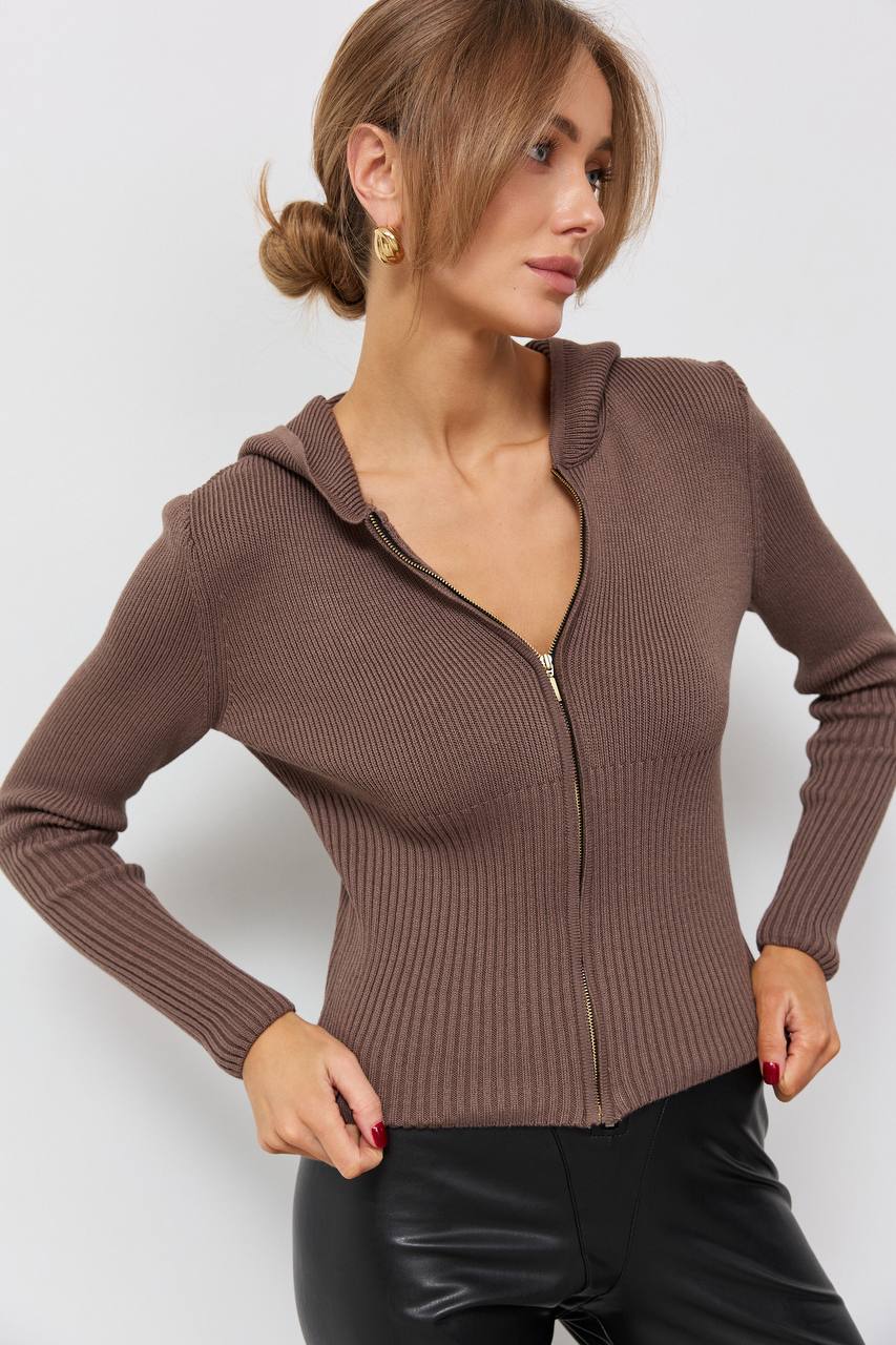 Woman wearing a brown zip-up hoodie against a white background