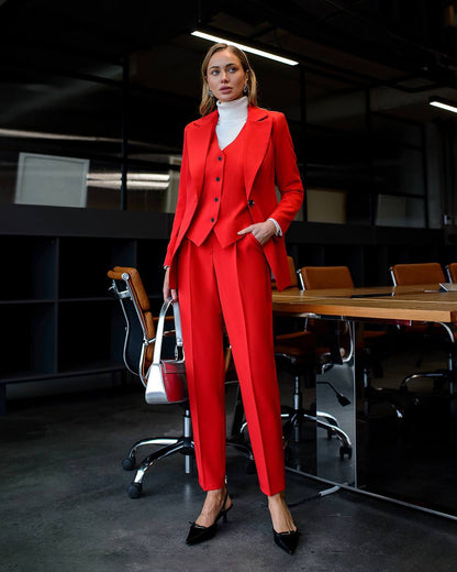 Woman in a red suit standing in an office setting