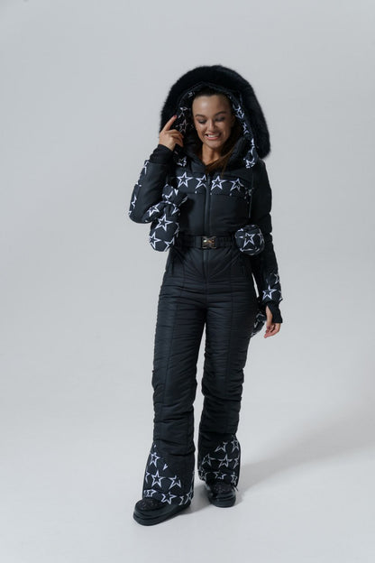 Person wearing a black snowsuit with star patterns on a white background