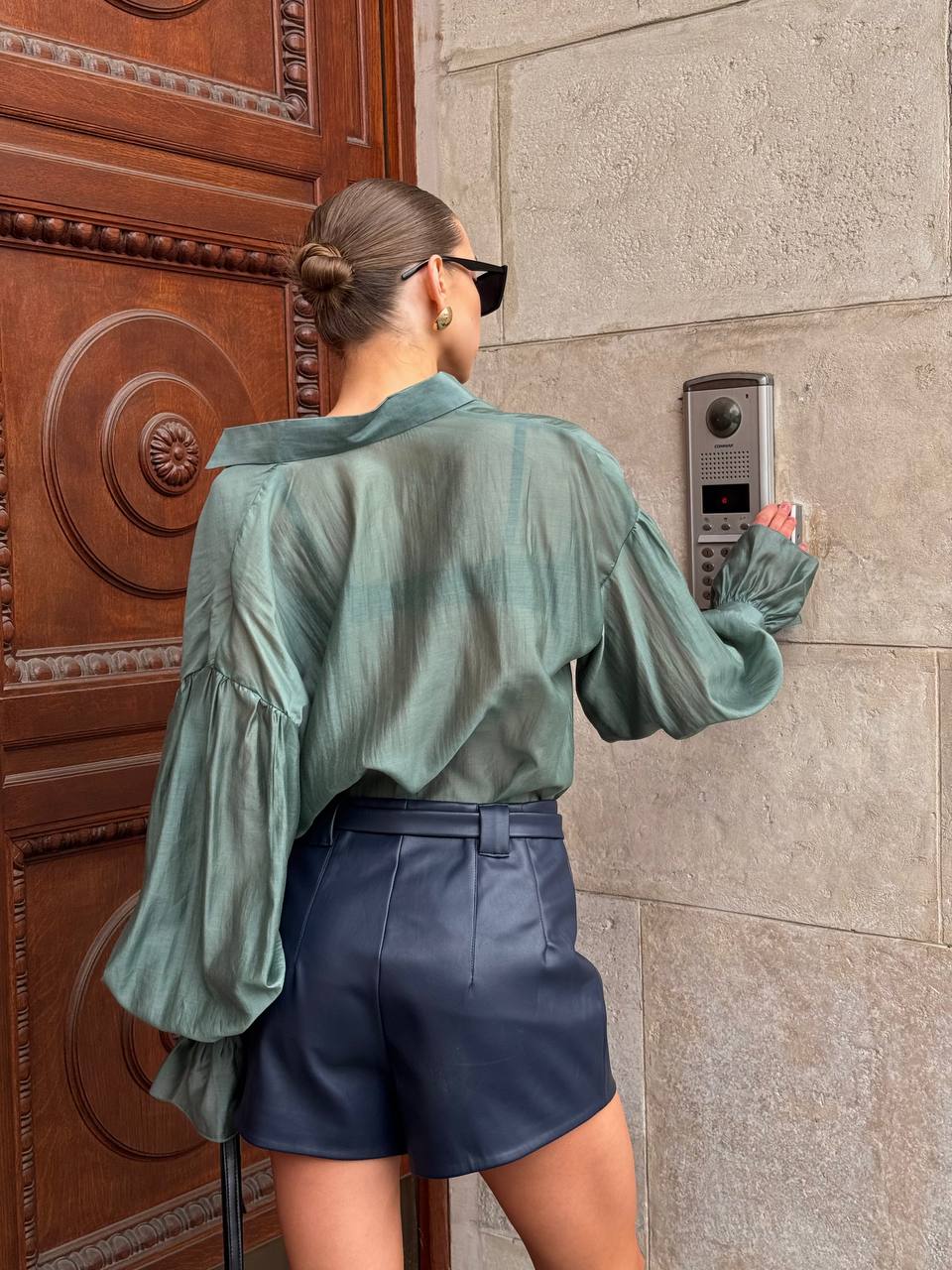 Person using a door intercom system on a stone wall.