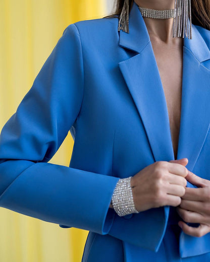 Blue blazer worn by a person against a yellow background