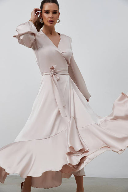 Woman wearing a light pink dress with a plain background